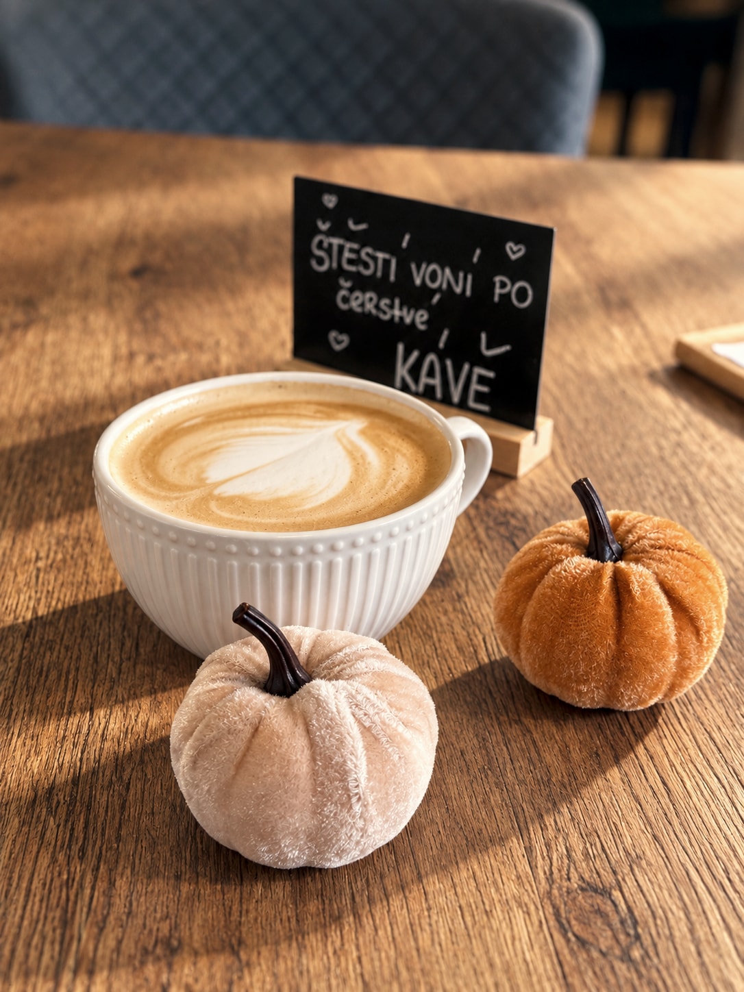 Cappuccino mit zwei dekorativen Kürbissen im Obývák