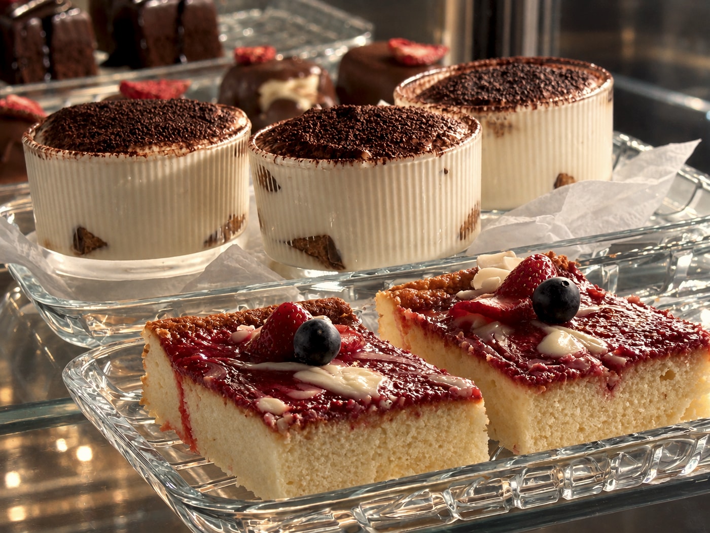 Výběr tiramisu a ovocných řezů ve vitríně